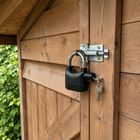 Black alarmed key padlock securing a sheltered dry garden shed latch