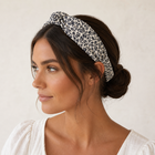 Woman wearing the cream and navy floral knotted headband with a low bun
