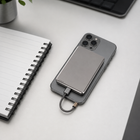 Slim grey power bank charging a smartphone on a work desk