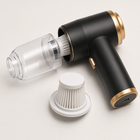 Mini car vacuum with clear dust cup removed to show the washable filter and USB-C port