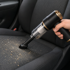 Cordless mini vacuum using the brush attachment on a fabric car seat