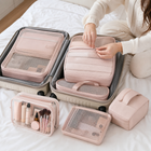 Traveller closing the zip on a blush pink packing cube set