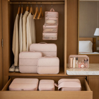 Blush pink packing organisers arranged in a hotel wardrobe and drawer