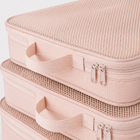 Close-up of blush pink packing cube mesh panels, carry handles and double zips