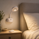 White rechargeable wall light mounted beside a bed with warm reading light