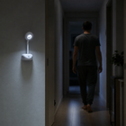 White motion-sensing rechargeable light illuminating an indoor hallway