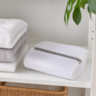 Folded shoe washing bag stored neatly on a laundry shelf