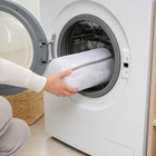 Protective shoe washing bag being placed in a front-loading washing machine